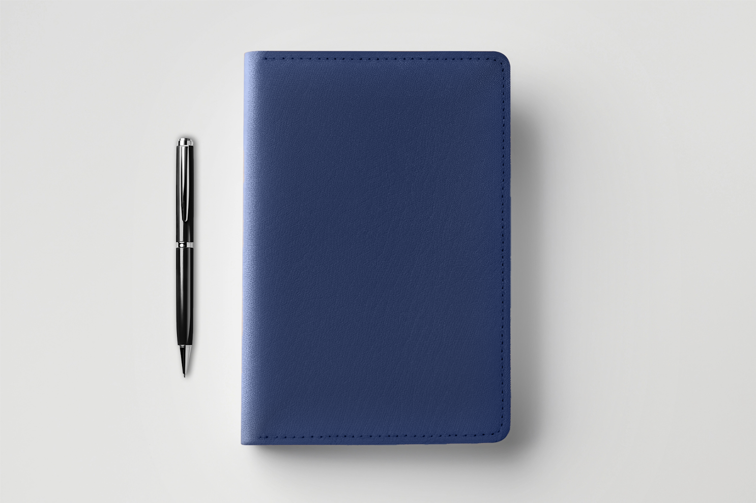 nb-stationary-home-ds Blue notebook and pen on white background.